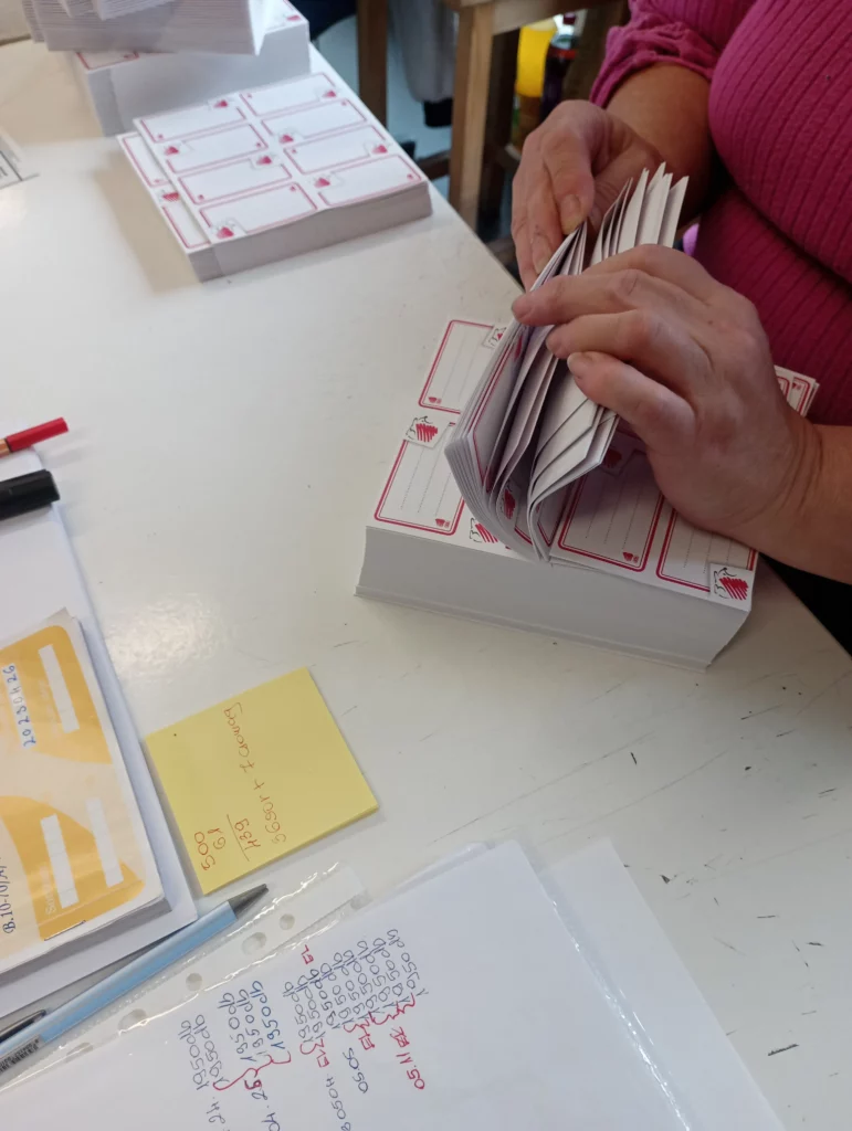 Betanított munkás az öntapadós füzetcímkék számolását végzi.