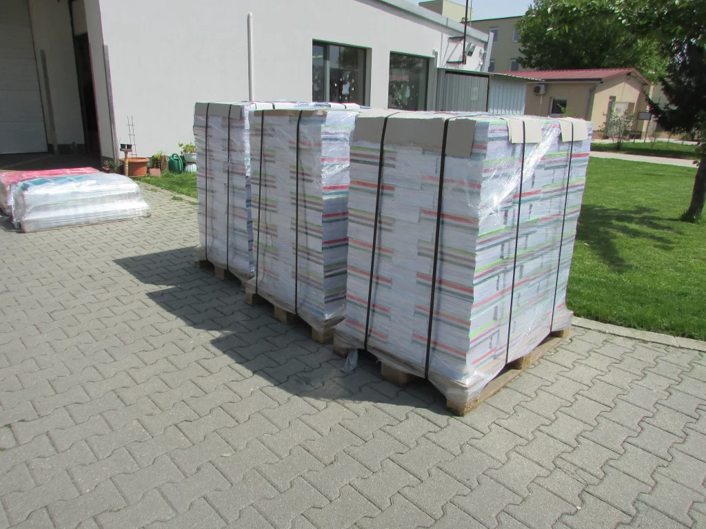 Az áru körbefóliázva, lepántolva és raklapokra helyezve elszállításra készen a csomagoló üzem mögötti rakodóterületen.