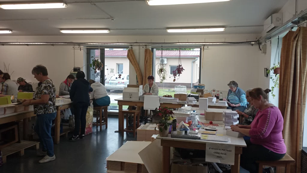 A dolgozók a papíráruk válogatását, összerendezését és fóliázását végzik a csomagoló üzemben.